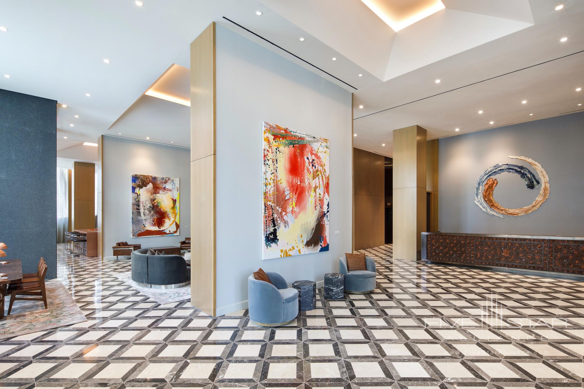The lobby at The Joseph, a Luxury Collection Hotel, Nashville, features a custom-designed reception desk with leather paneling by Lucchese, and ceramic art by artist Brie Ruais (behind desk) and paintings by artist Jackie Saccoccio.
