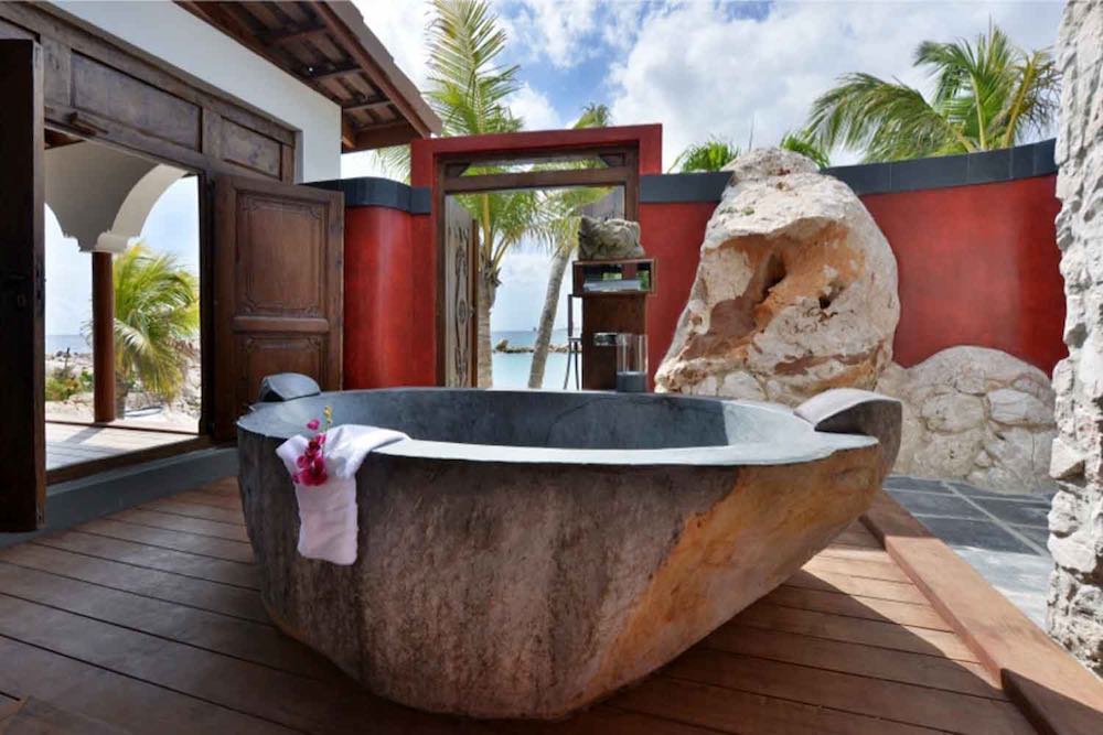 Outdoor bathroom and tub in a Superior Beachfront pool suite at the Baoase Luxury Resort in Curaçao